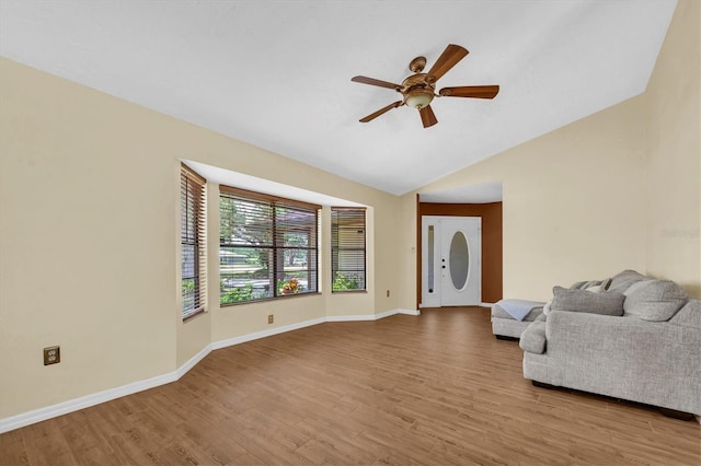 unfurnished living room with baseboards, ceiling fan, vaulted ceiling, and wood finished floors