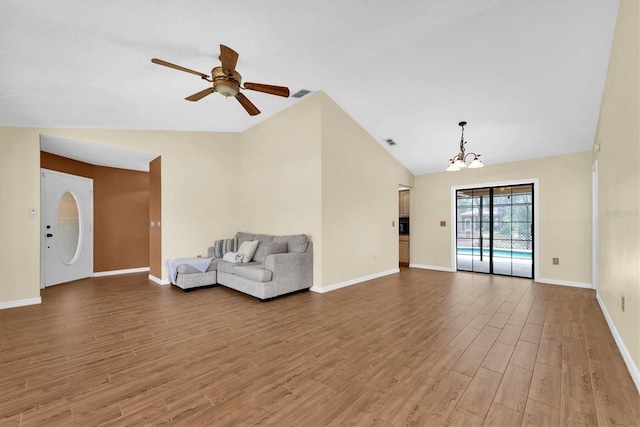 unfurnished living room with visible vents, wood finished floors, lofted ceiling, baseboards, and ceiling fan with notable chandelier