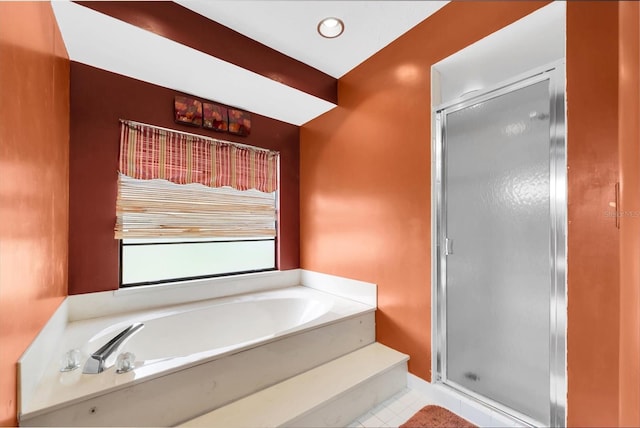 bathroom with tile patterned flooring, a shower stall, and a garden tub