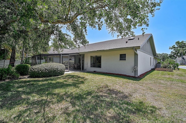 7817 Pine Trace Dr Unit 15, Sarasota, FL 34243 - rear view of property featuring a lawn, central air condition unit, and a shingled roof