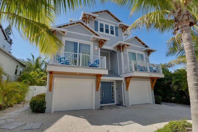 view of front of home with a garage, a balcony, and fence