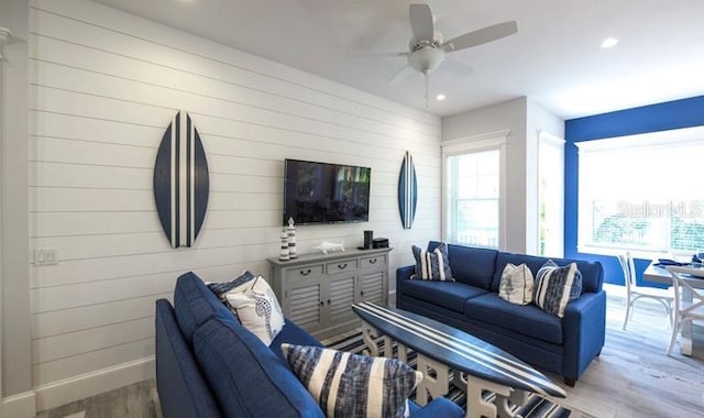 living area with wood finished floors, recessed lighting, baseboards, ceiling fan, and wooden walls