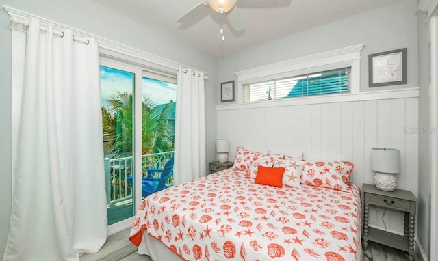 bedroom with access to exterior, light wood-style floors, ceiling fan, and a wainscoted wall