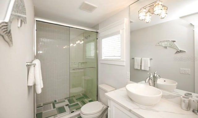 bathroom with a stall shower, vanity, and toilet