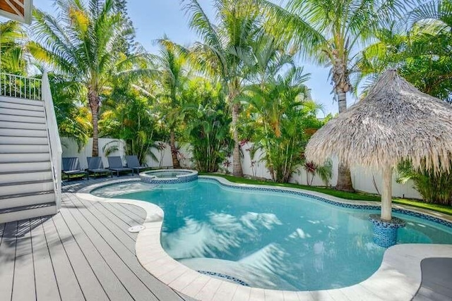 view of swimming pool with a fenced backyard and a pool with connected hot tub