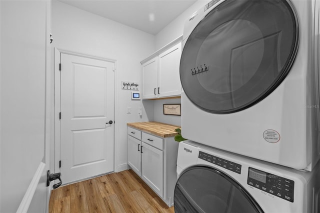 11430 Gallatin Trl, Parrish, FL 34219 - washroom featuring stacked washer / dryer, cabinet space, and light wood finished floors