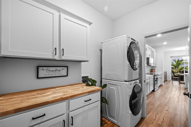11430 Gallatin Trl, Parrish, FL 34219 - washroom with estacked washer and dryer, cabinet space, light wood-style floors, and recessed lighting
