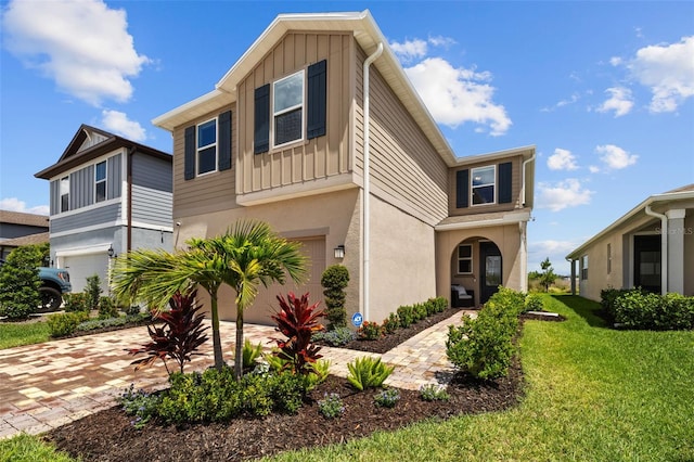 11430 Gallatin Trl, Parrish, FL 34219 - view of front of house with a garage, board and batten siding, decorative driveway, stucco siding, and a front lawn