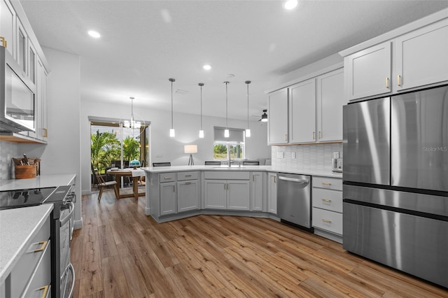 11430 Gallatin Trl, Parrish, FL 34219 - kitchen featuring appliances with stainless steel finishes, light countertops, a peninsula, recessed lighting, and light wood-type flooring