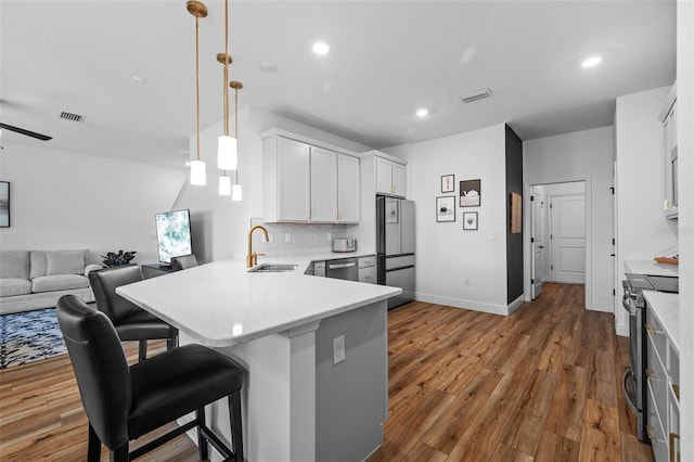 11430 Gallatin Trl, Parrish, FL 34219 - kitchen featuring stainless steel appliances, a sink, a peninsula, open floor plan, and a breakfast bar
