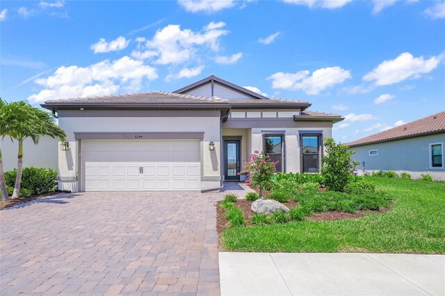 6244 Talon Preserve Dr, Nokomis, FL 34275 - prairie-style home with stucco siding, decorative driveway, a front yard, and a garage