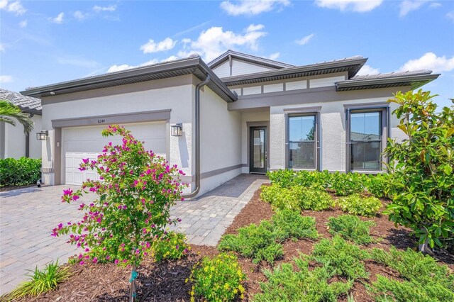 6244 Talon Preserve Dr, Nokomis, FL 34275 - prairie-style house with decorative driveway, an attached garage, and stucco siding
