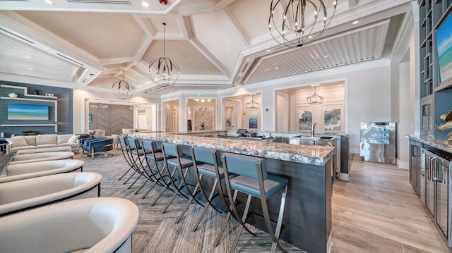 6244 Talon Preserve Dr, Nokomis, FL 34275 - interior space with light stone countertops, a kitchen bar, a large island with sink, a notable chandelier, and hanging light fixtures