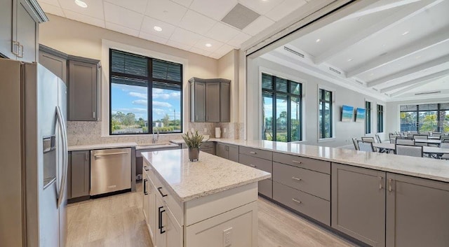 6244 Talon Preserve Dr, Nokomis, FL 34275 - kitchen featuring appliances with stainless steel finishes, gray cabinets, backsplash, and light wood-style flooring