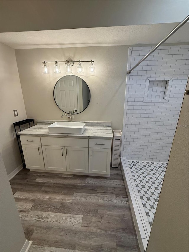 full bath with vanity, wood finished floors, and a shower stall