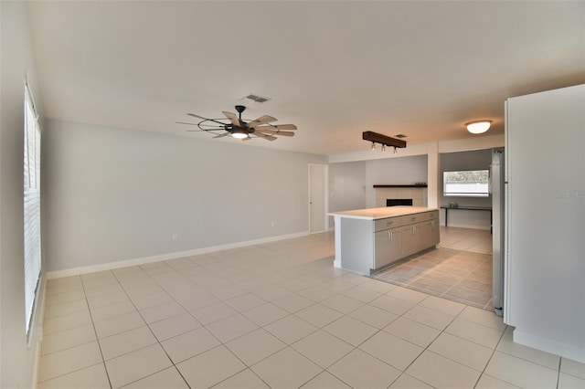 2402 16th St W, Palmetto, FL 34221 - kitchen with gray cabinets, open floor plan, a fireplace, light countertops, and light tile patterned floors