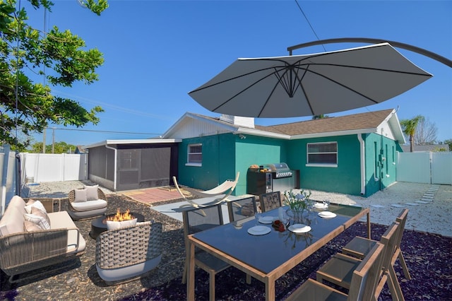 2402 16th St W, Palmetto, FL 34221 - back of house with a sunroom, an outdoor fire pit, a fenced backyard, a patio, and outdoor dining space