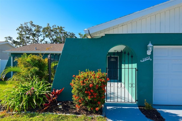 2402 16th St W, Palmetto, FL 34221 - doorway to property with a garage, roof with shingles, and fence