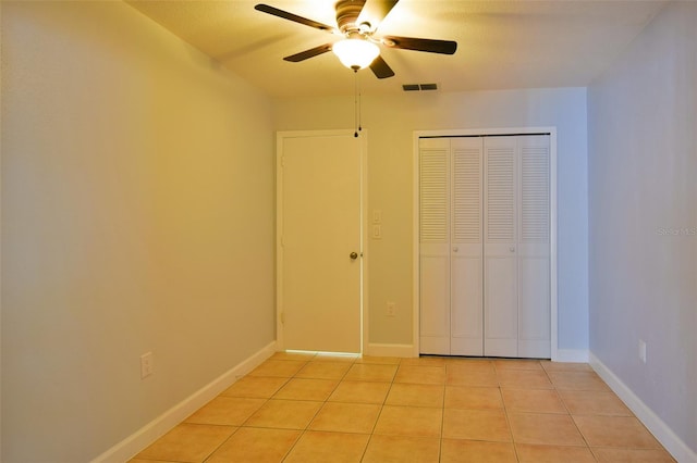 2402 16th St W, Palmetto, FL 34221 - unfurnished bedroom with light tile patterned floors, a closet, and ceiling fan