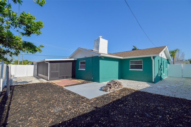 2402 16th St W, Palmetto, FL 34221 - back of property featuring a sunroom, a fenced backyard, a chimney, and a patio