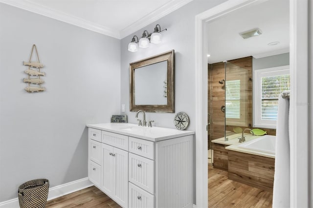 bathroom featuring crown molding, vanity, wood finished floors, tiled shower, and a tub to relax in
