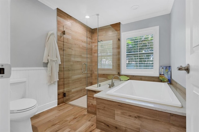 bathroom featuring toilet, a shower stall, wood finished floors, and a bath