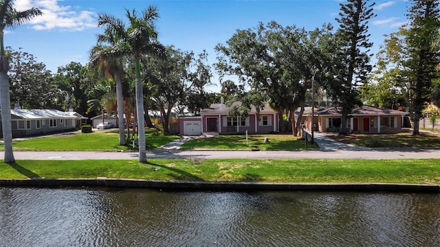 1830 Virginia Dr, Bradenton, FL 34205 - view of front facade with a water view, driveway, a front lawn, and a garage