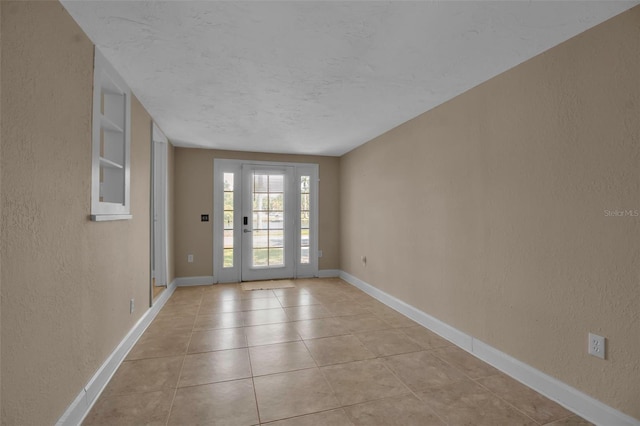 1830 Virginia Dr, Bradenton, FL 34205 - interior space featuring light tile patterned flooring, a textured wall, and baseboards