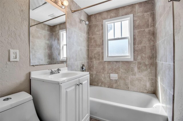 1830 Virginia Dr, Bradenton, FL 34205 - full bathroom with toilet, tub / shower combination, vanity, and a textured wall