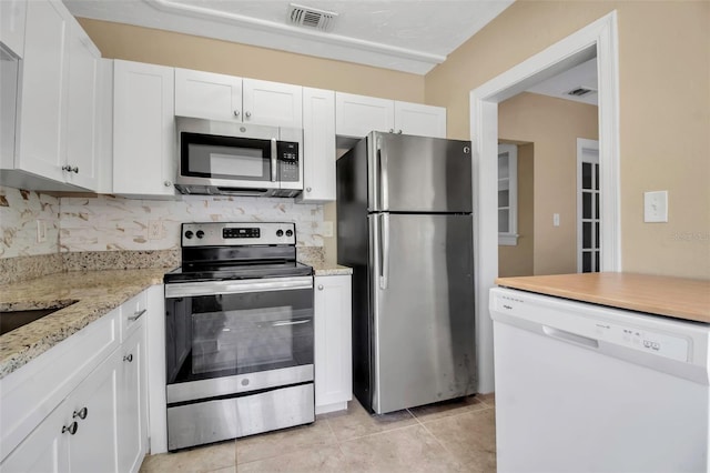 1830 Virginia Dr, Bradenton, FL 34205 - kitchen featuring white cabinetry, backsplash, stainless steel appliances, and visible vents
