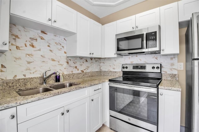 1830 Virginia Dr, Bradenton, FL 34205 - kitchen featuring white cabinetry, stainless steel appliances, tasteful backsplash, and a sink