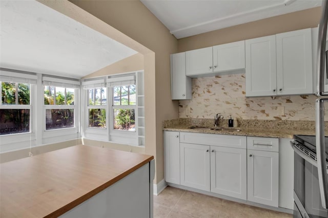 1830 Virginia Dr, Bradenton, FL 34205 - kitchen with white cabinetry, range with electric cooktop, a sink, and vaulted ceiling