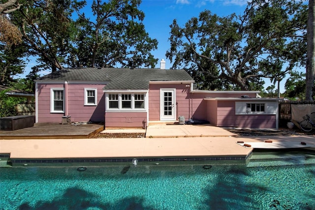 1830 Virginia Dr, Bradenton, FL 34205 - back of property featuring a wooden deck, a patio, a chimney, and an outdoor pool