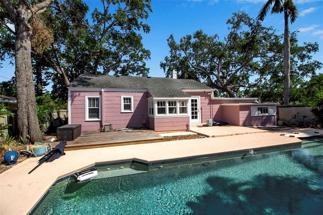 1830 Virginia Dr, Bradenton, FL 34205 - back of house featuring a patio area, a chimney, a wooden deck, and an outdoor pool
