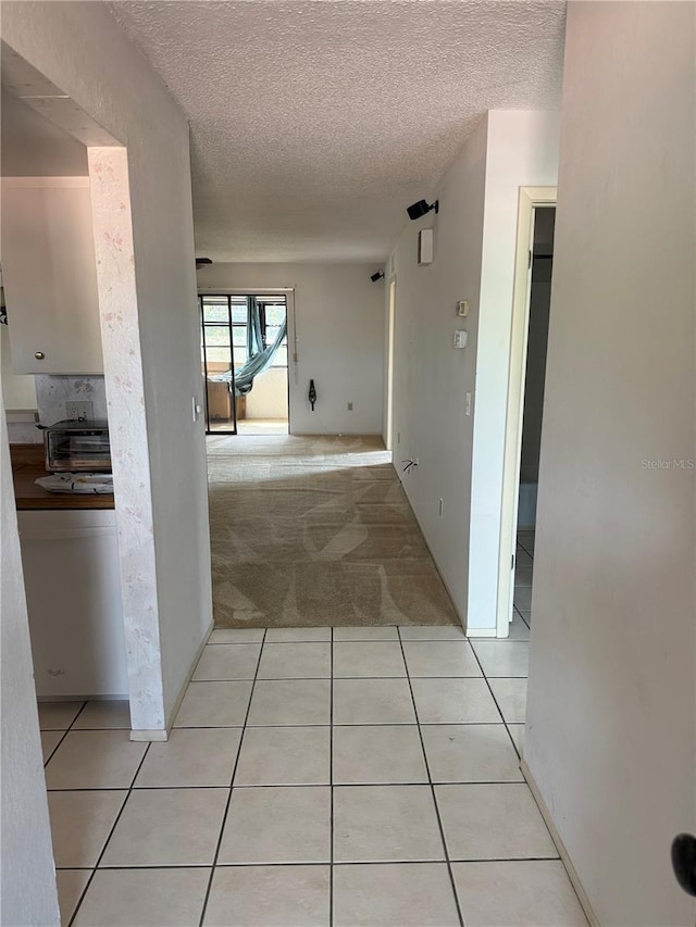 2808 60th Ave W Unit 1924, Bradenton, FL 34207 - hall featuring a textured ceiling, light carpet, and light tile patterned floors