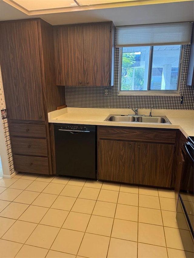 kitchen featuring light tile patterned flooring, dark brown cabinets, black dishwasher, light countertops, and a sink
