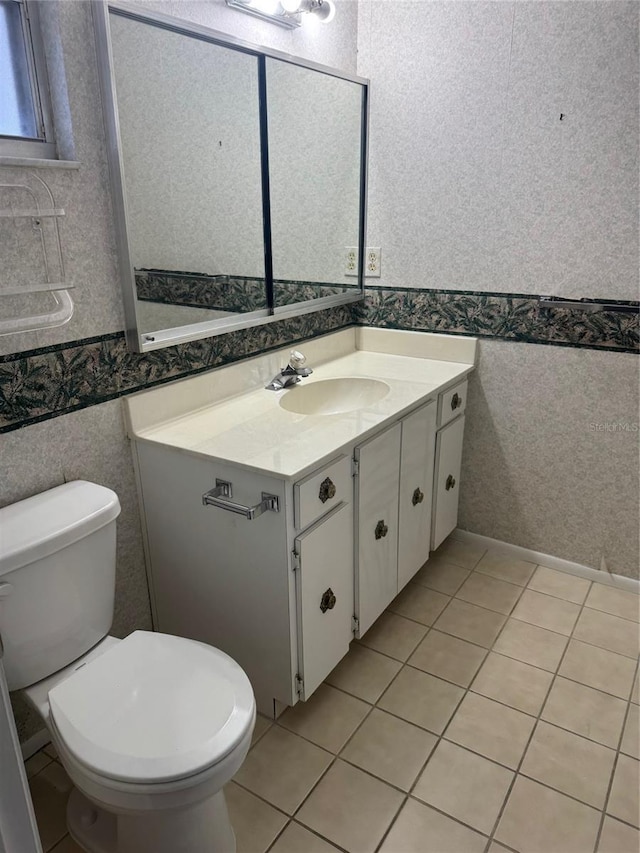 bathroom with toilet, wallpapered walls, tile patterned floors, and vanity