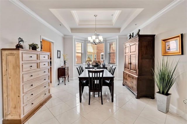 dining space with a chandelier, a raised ceiling, baseboards, and ornamental molding