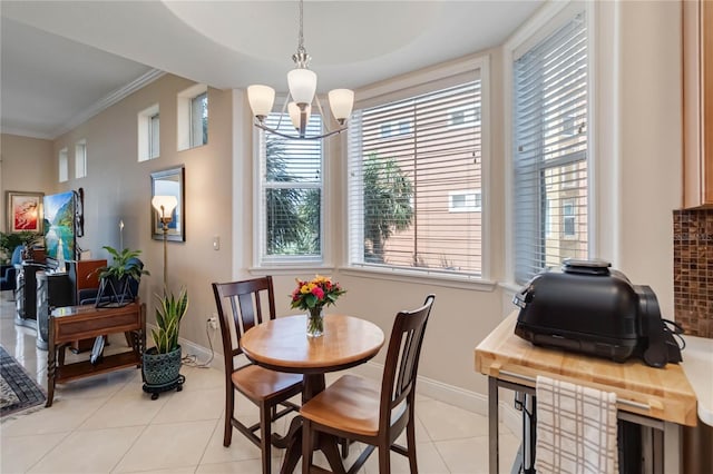 dining space with a chandelier, light tile patterned flooring, baseboards, and crown molding