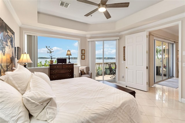bedroom featuring access to exterior, multiple windows, a raised ceiling, and light tile patterned flooring
