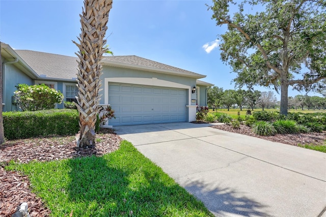 view of front of home with stucco siding, driveway, and a garage