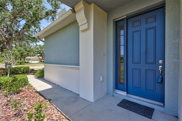 view of exterior entry featuring stucco siding