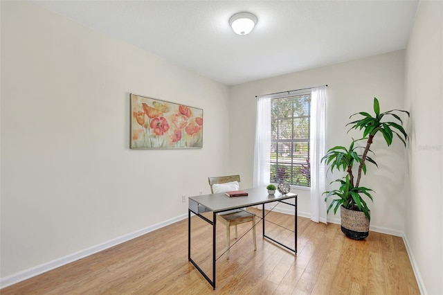 office area featuring baseboards and light wood-style flooring