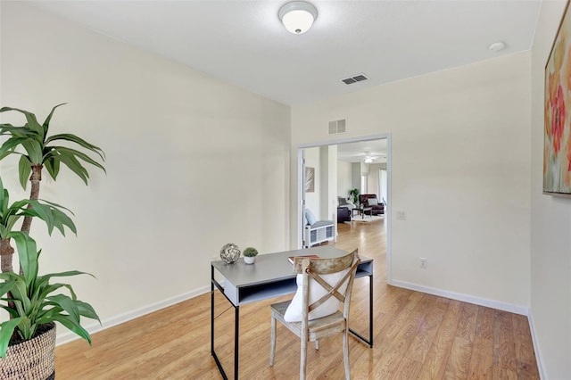 dining room featuring baseboards, ceiling fan, light wood-style flooring, and visible vents