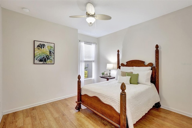 bedroom featuring a ceiling fan, baseboards, and light wood-style flooring