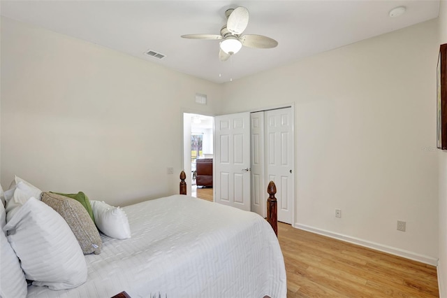 bedroom with baseboards, a ceiling fan, light wood-type flooring, and visible vents