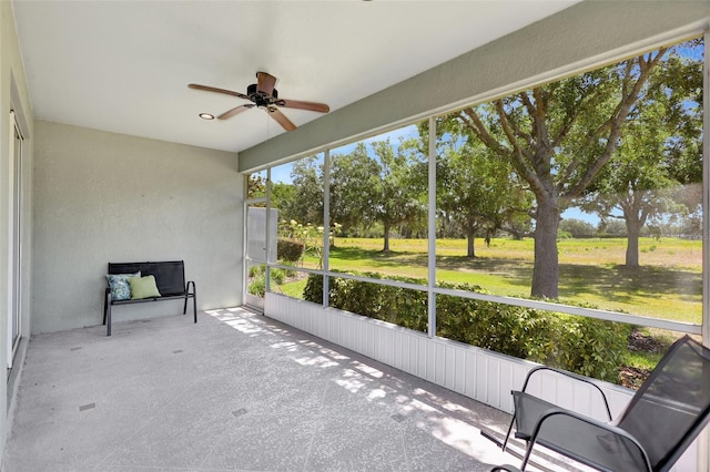 unfurnished sunroom with a ceiling fan