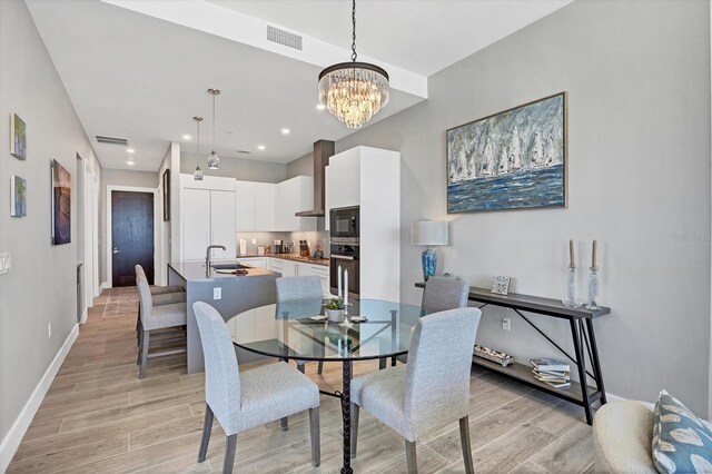 33 S Palm Ave Unit 1403, Sarasota, FL 34236 - dining space with an inviting chandelier, light wood finished floors, baseboards, and visible vents