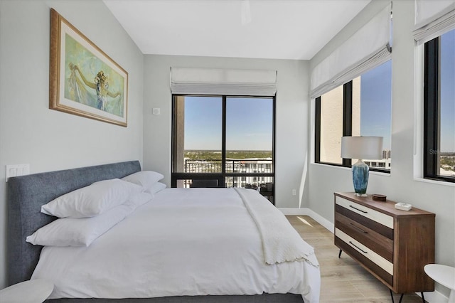 33 S Palm Ave Unit 1403, Sarasota, FL 34236 - bedroom with access to outside, baseboards, multiple windows, and light wood-style floors