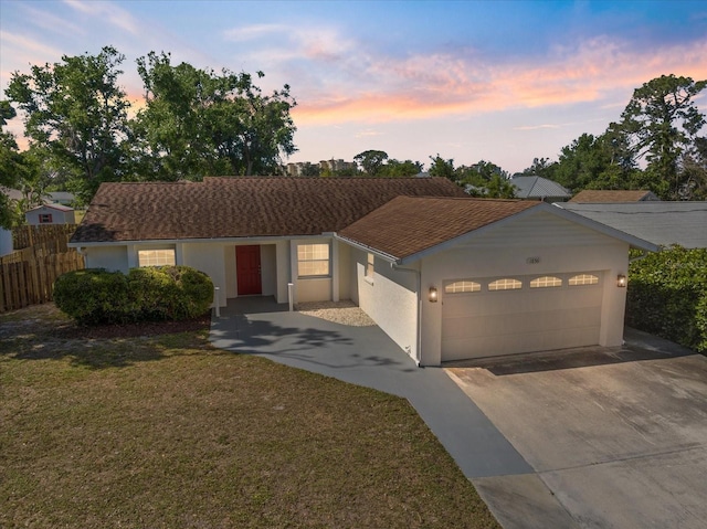 single story home with fence, a garage, stucco siding, concrete driveway, and a lawn